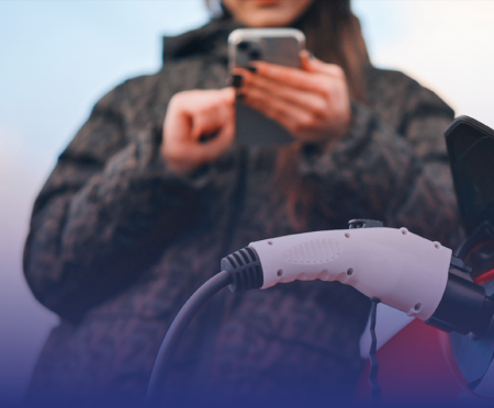 Mit Roadrunner Couponline Plus ganz einfach per Smartphone laden – modern, flexibel und immer mit den besten Konditionen. Frau mit Smartphone lädt Elektroauto – Roadrunner Couponline Plus Vorteile